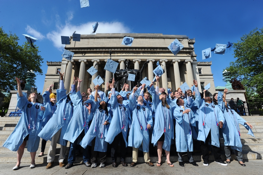 Military Veterans throwing caps into air on Lowe Library steps at 2019 graduation.